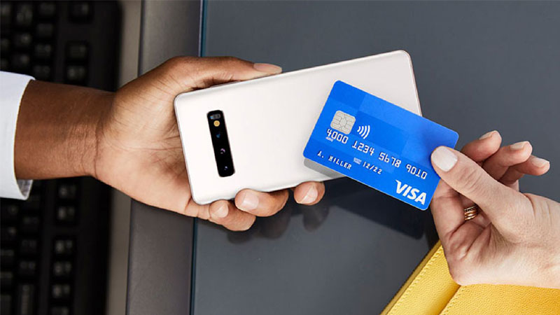 Persona haciendo un pago con tarjeta Visa mediante la tecnología Tap to Phone